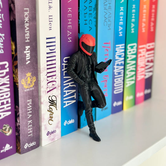 Шелфи моторист четящ книга.